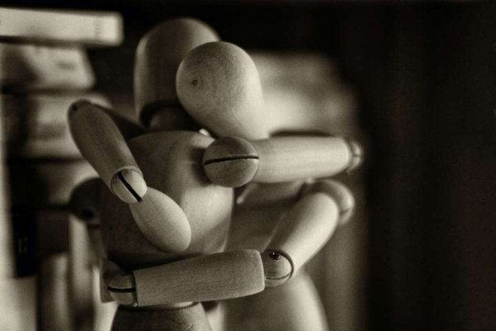 Dos muñecos de madera se abrazan