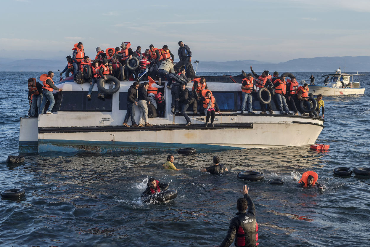 Refugiados sirios e iraquíes tratan de desembarcar en las aguas costeras de Lesbos en Grecia, después de haber cruzado desde Turquía. 2015