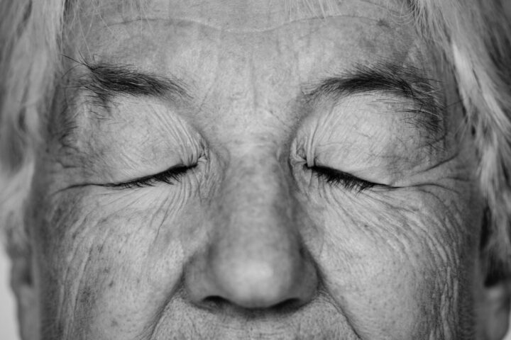 Rostro de una anciana con los ojos cerrados, foto en blanco y negro.